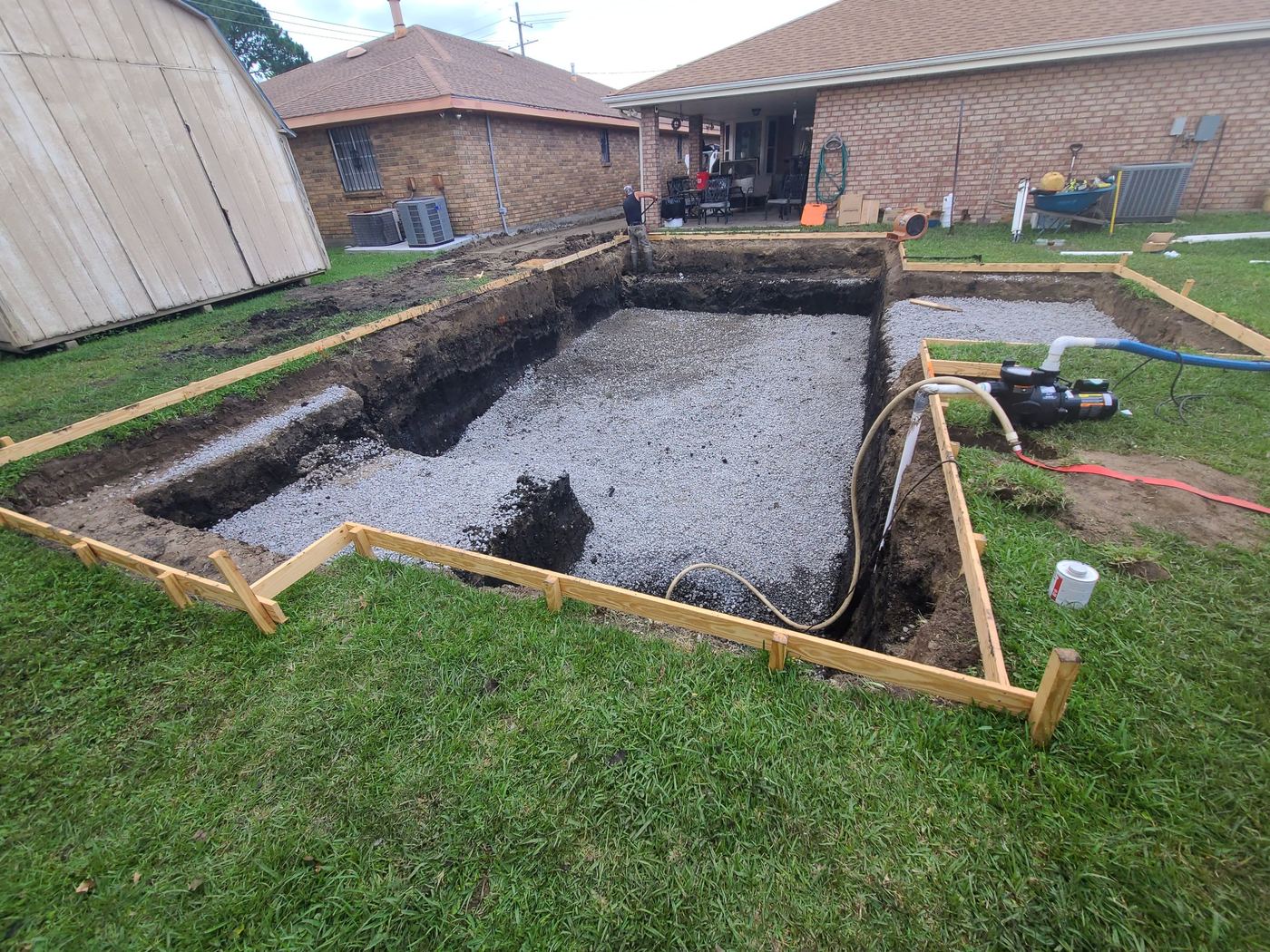 Step 3 of 14, Dig: A gravel base spread across the bottom of the dig.