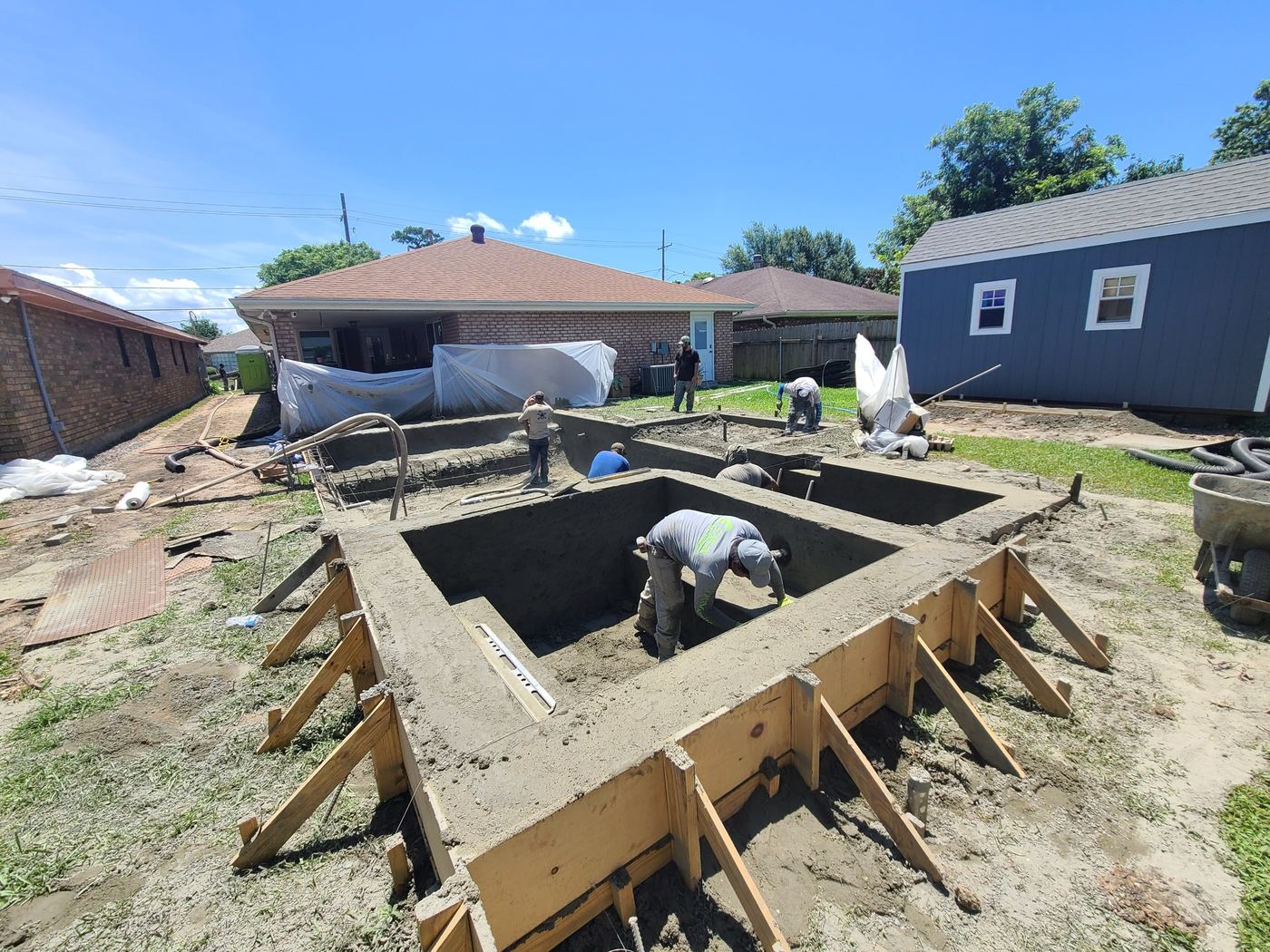 Step 6 of 14, Gunite: The crew shapes the raised spa while gunite goes in.