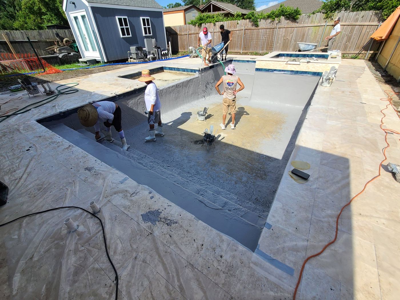Step 13 of 14, Interior finish: The crew applies the pool's interior finish.