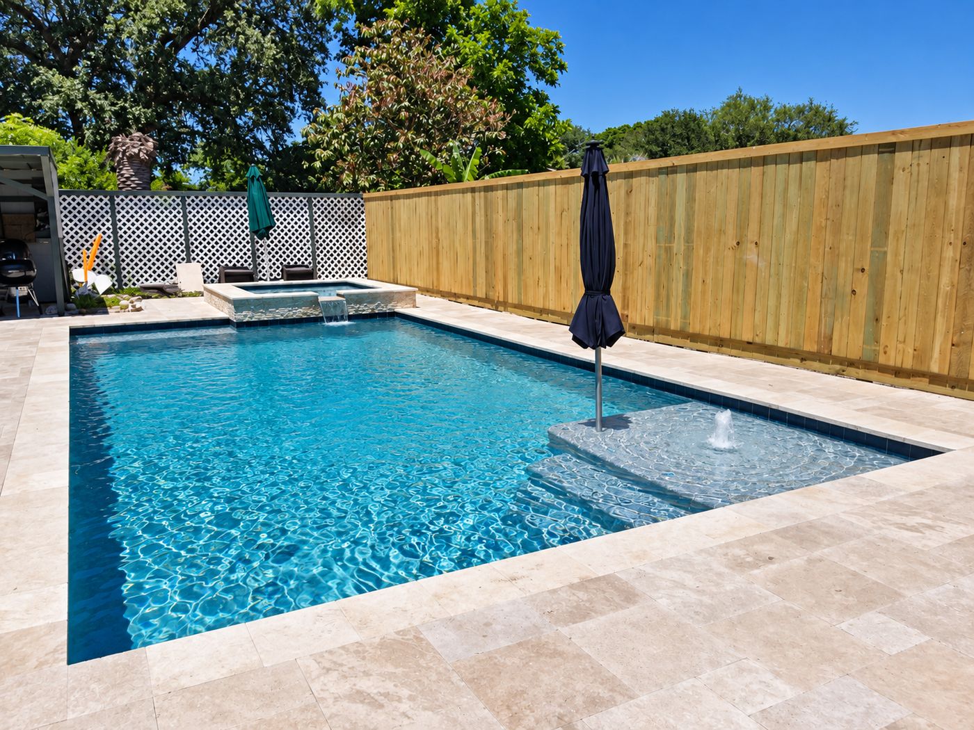 Rectangular pool with a sun shelf bubbler and spa spillover